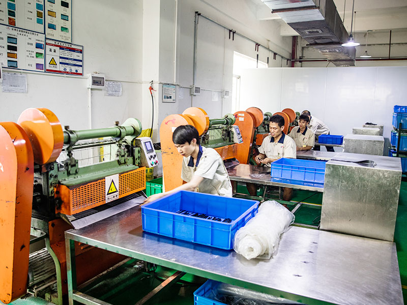Workers operating rubber processing machines in an industrial manufacturing workshop