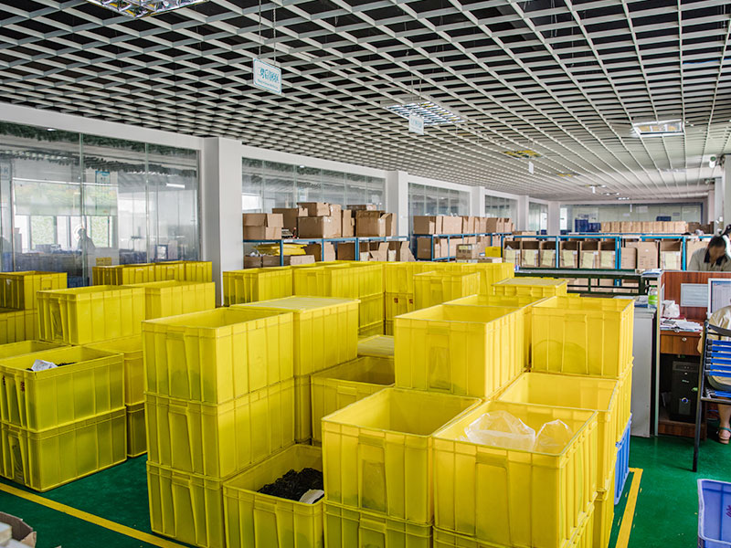 Rubber parts factory storage area with yellow plastic bins and organized inventory