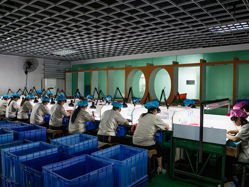 Workers performing manual quality inspection in a rubber parts manufacturing workshop